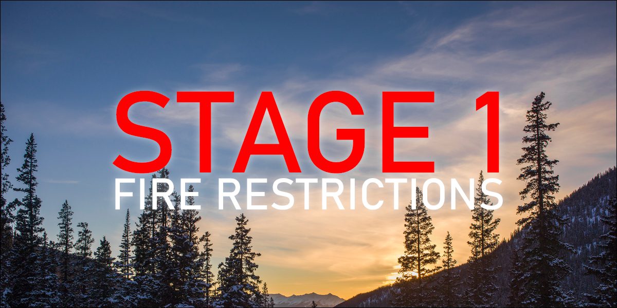 Trees and mountains with the text "Stage 1 Fire Restrictions"