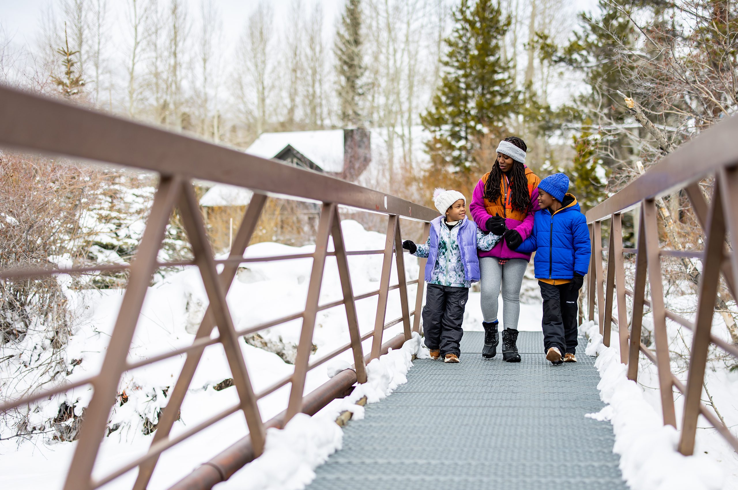 Family walking on bridge over Tenmile Creek during winter